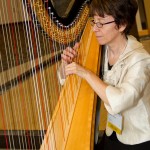 Diana Gumas, IT Director for JH SOM playing the harp